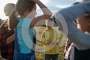 Portrait of young classmate playing hand clapping game outdoors. Students during field teaching class, standing in the