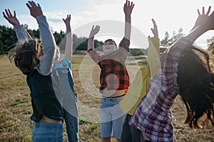 Portrait of young classmates, students during biology field teaching class, successful experiment, hands in air