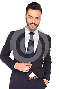 Portrait of a young confident business man closing his suit