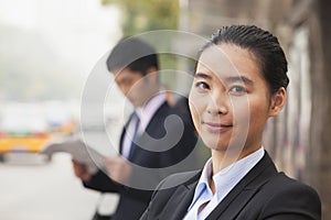 Portrait of young, confident businesswoman looking at the camera and smiling in the street, Beijing, China