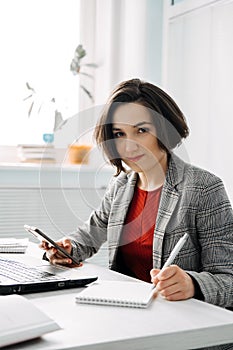 Portrait of young confident businesswoman in modern office. Woman-Owned Business,