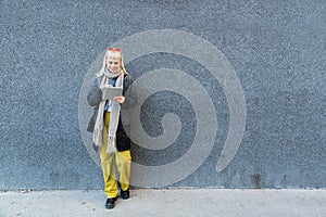 Portrait of young confident fashionable freelance woman with cool attitude working on digital tablet outside office building.