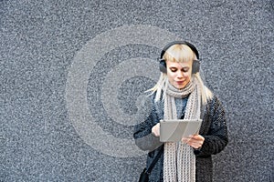 Portrait of young confident fashionable freelance woman with cool attitude working on digital tablet outside office building.