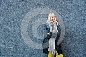 Portrait of young confident fashionable woman with cool attitude. Hipster stylish female posing against black wall