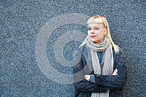 Portrait of young confident fashionable woman with cool attitude. Hipster stylish female posing against black wall