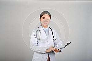 Portrait of young confident female doctor standing with white isolated background