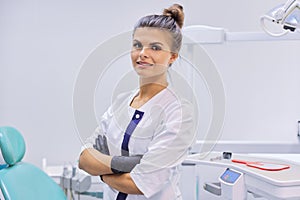 Portrait of young confident smiling dentist doctor woman, female with arms crossed