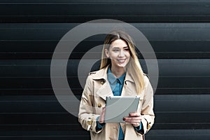 Portrait of young confident successful business woman standing outside office building. Educated independent female team leader