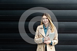 Portrait of young confident successful business woman standing outside office building. Educated independent female team leader