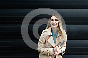 Portrait of young confident successful business woman standing outside office building. Educated independent female team leader