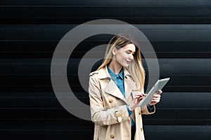 Portrait of young confident successful business woman standing outside office building. Educated independent female team leader