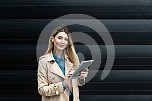 Portrait of young confident successful business woman standing outside office building. Educated independent female team leader