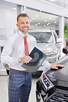 Portrait of young consultant of cars showroom