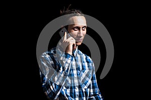 Portrait of young cool man with dreadlocks talking on the phone