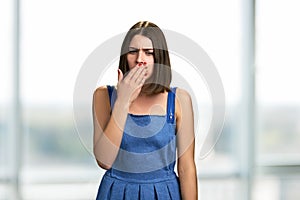 Portrait of young coughing woman.