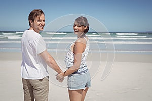 Portrait of young couple holding hands at beach