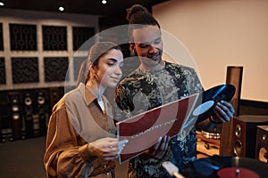 Portrait of young couple holding vnyl records while enjoying music