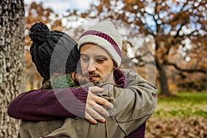 Portrait young couple hugging in an autumn background. Back view