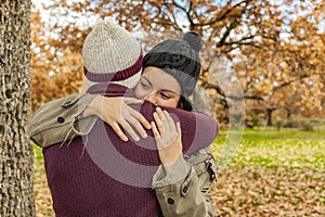 Portrait young couple hugging in an autumn background. Back view