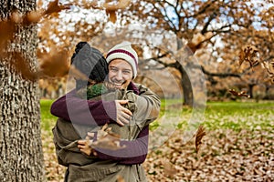 Portrait young couple hugging in a rain of leaves. Back view of