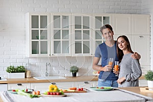 Portrait of young couple in the kitchen with carrot juice. Healthy eating