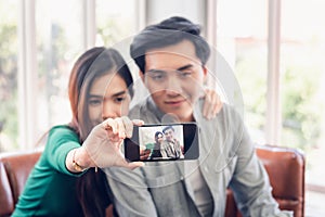 Portrait of Young Couple Love Capturing Selfie on Mobile Phone at Their Home, Attractive Asian Couple Making Selfie and Smile