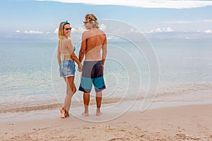 Portrait of young couple in love embracing at beach and enjoying time being together. Idealistic artistic photo poster