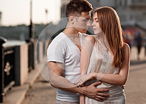 Portrait of young couple in love, enjoying the sunset in city