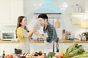 Portrait young couple in love helping to cook In a romantic atmosphere at home and looking at camera with smile face