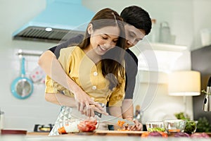 Portrait young couple in love helping to cook In a romantic atmosphere at home with smile face