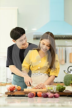 Portrait young couple in love helping to cook In a romantic atmosphere at home with smile face