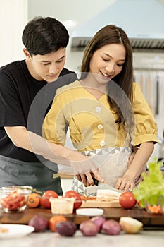 Portrait young couple in love helping to cook In a romantic atmosphere at home with smile face