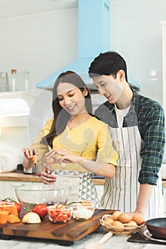 Portrait young couple in love helping to cook In a romantic atmosphere at home with smile face