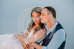 Portrait of a young couple. A man gently hugs a woman. Wedding photography, love story. Background white sands at sunset