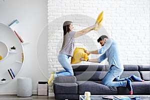 Portrait of Young Couple Playing Pillow Fight