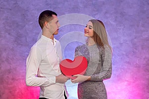 Portrait of young couple with red shape heart air balloons. Valentine`s day celebration concept