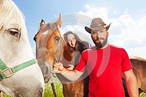 Portrait of young couple riding beautiful horses