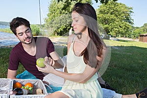 Portrait young couple during romantic picnic in countryside