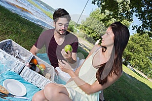 Portrait young couple during romantic picnic in countryside