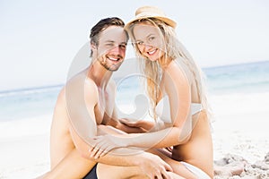 Portrait of young couple sitting together on the beach