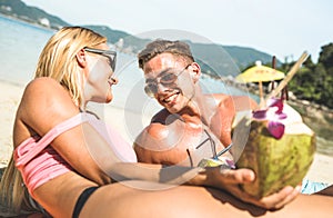 Portrait of young couple vacationer having fun on tropical Phuket beach in Thailand with coconut drink - Active youth and travel