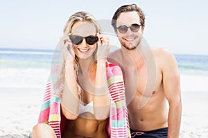 Portrait of young couple wearing sunglasses at beach