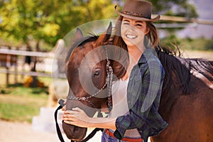 Go West young girl. Portrait of a young cowgirl standing outside with her horse.