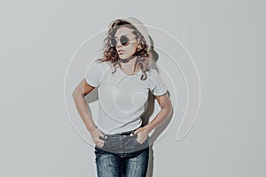 Portrait of young curly latin woman in straw hat and sunglasses smiling isolated over white background