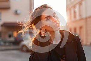 Portrait of a young cute attractive woman with a stylish hairstyle with beautiful eyes with sexy lips in fashionable black clothes