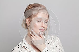 Portrait of young cute blonde woman on white background