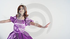 Portrait of a young cute girl in a beautiful princess costume isolated on white background. Bright colorful character with brown