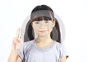 Portrait of young cute girl posting with thtee fingers. photo