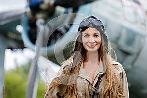 Portrait of a young cute woman pilot in a helmet and pilot suit