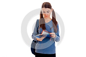 Portrait of young cutie student girl with backpack and notebooks isolated on white background